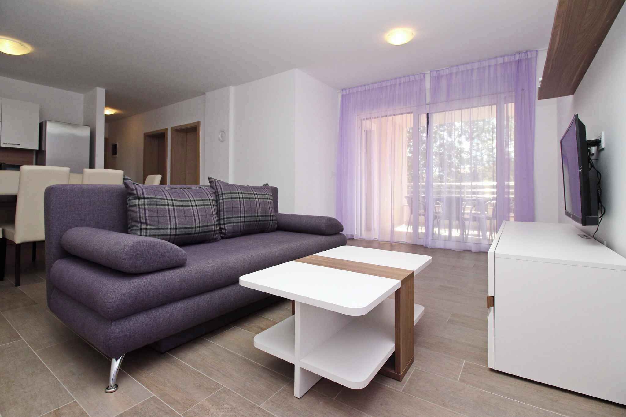 A modern living room with a sofa, a coffee table, and a TV.