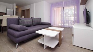 Un salon moderne avec un canapé, une table basse et un téléviseur.