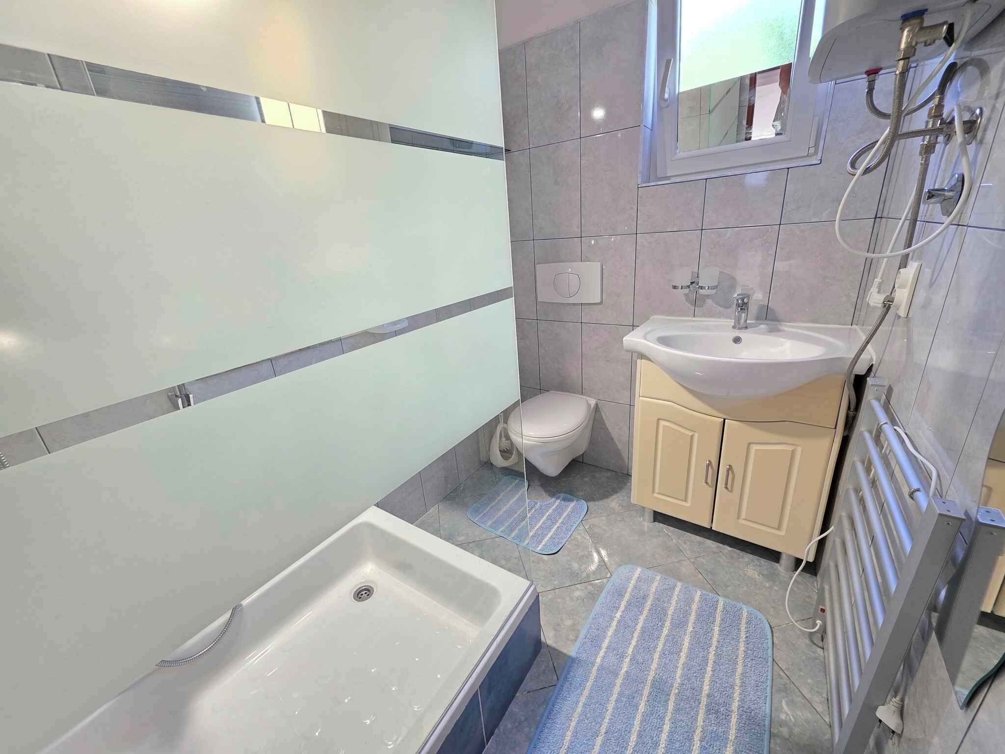 Une salle de bain avec une baignoire, des toilettes, un lavabo et un miroir.