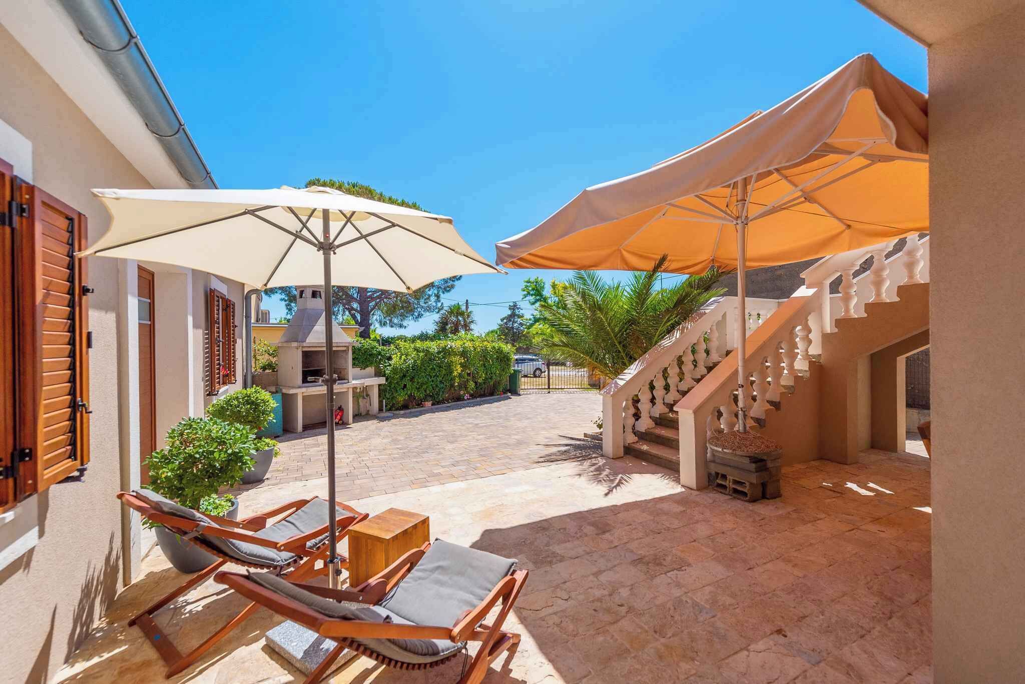 A patio area with outdoor seating, a staircase, and a view of the surrounding landscape.