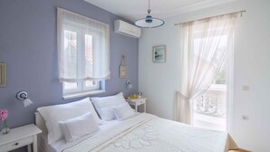 A bedroom with a bed, bedside table, and a window with curtains. - Holiday home Fully air-conditioned and modern (Privlaka)