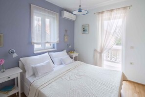 A bedroom with a bed, bedside table, and a window with curtains. - Holiday home Fully air-conditioned and modern (Privlaka)