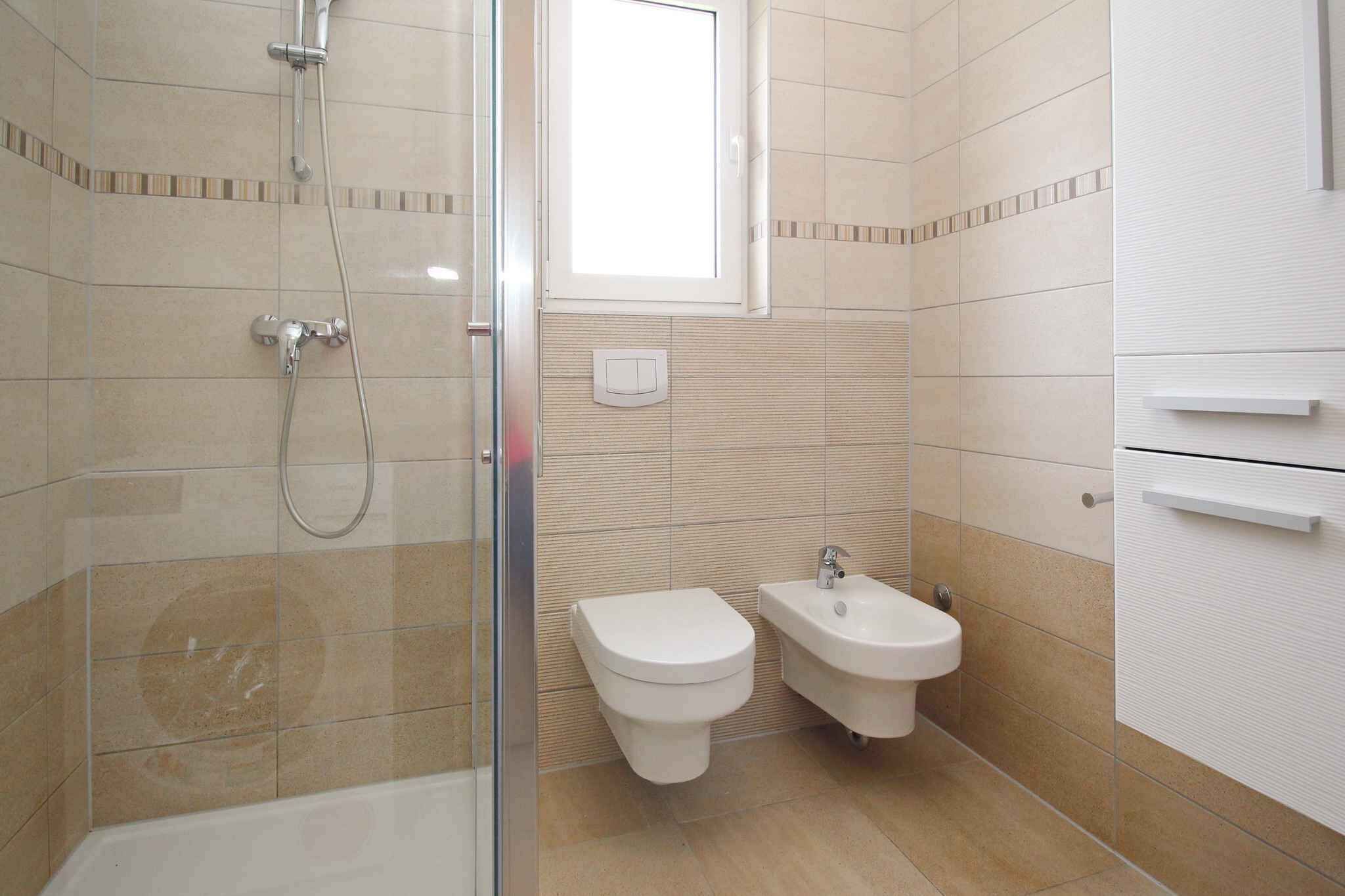 Ein Badezimmer mit Duschkabine, Toilette und Bidet.