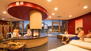 A spa area with a central fire feature, seating areas, and a view of the outdoors. - Holiday apartment at the Therme Obernsees (Mistelgau-Obernsees)