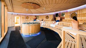 A wooden sauna with benches and a central hot tub. - Holiday apartment at the Therme Obernsees (Mistelgau-Obernsees)