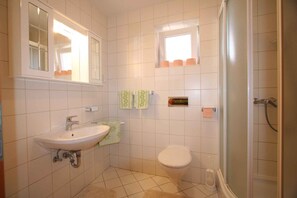 Ein Badezimmer mit Waschbecken, Toilette und Dusche.