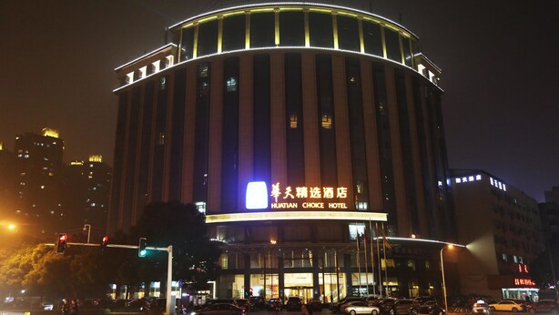 A hotel with a circular facade and illuminated signage.