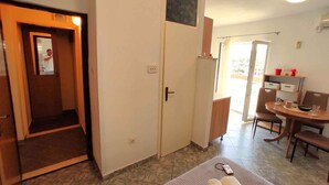 Una habitación con cama, escritorio, silla, una mesita y ventana.