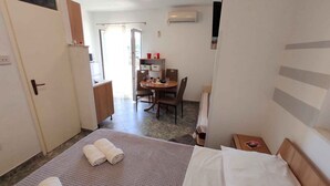 Habitación de hotel con cama, escritorio, silla y una mesita.