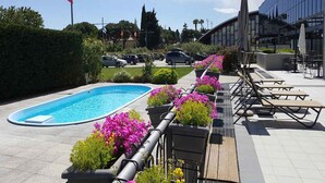 A swimming pool, outdoor seating, and a modern building. - Holiday apartment mit Klimaanlage und Pool (Loano)