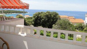 Un balcon avec vue sur la mer et une ville côtière.
