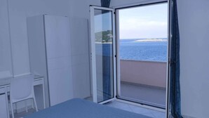 Un balcón con puerta de vidrio que da a vistas del mar.