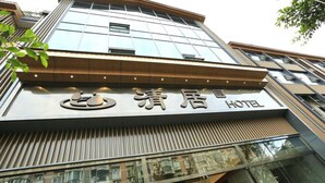 Ein Hotel mit moderner Fassade, großen Fenstern und einem gut sichtbaren Logo.