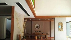 Ein modernes Interieur mit Essbereich, einem fußbodenhohen, kreisförmigen Muster und einer Holzsäule.