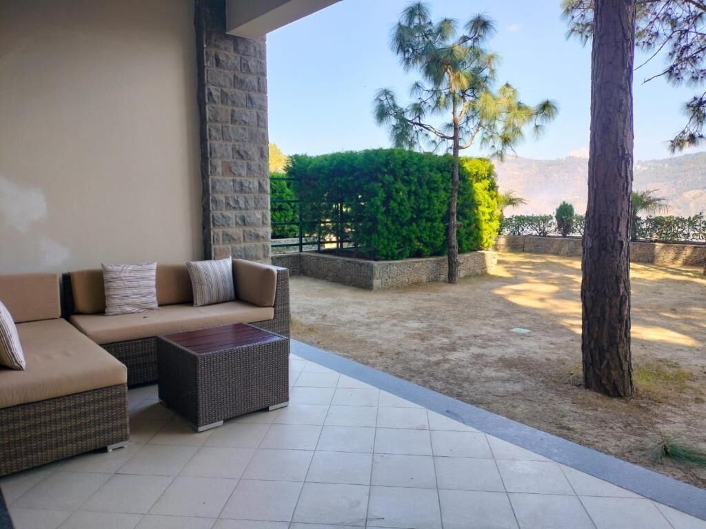 A covered outdoor seating area with a sofa and a coffee table.