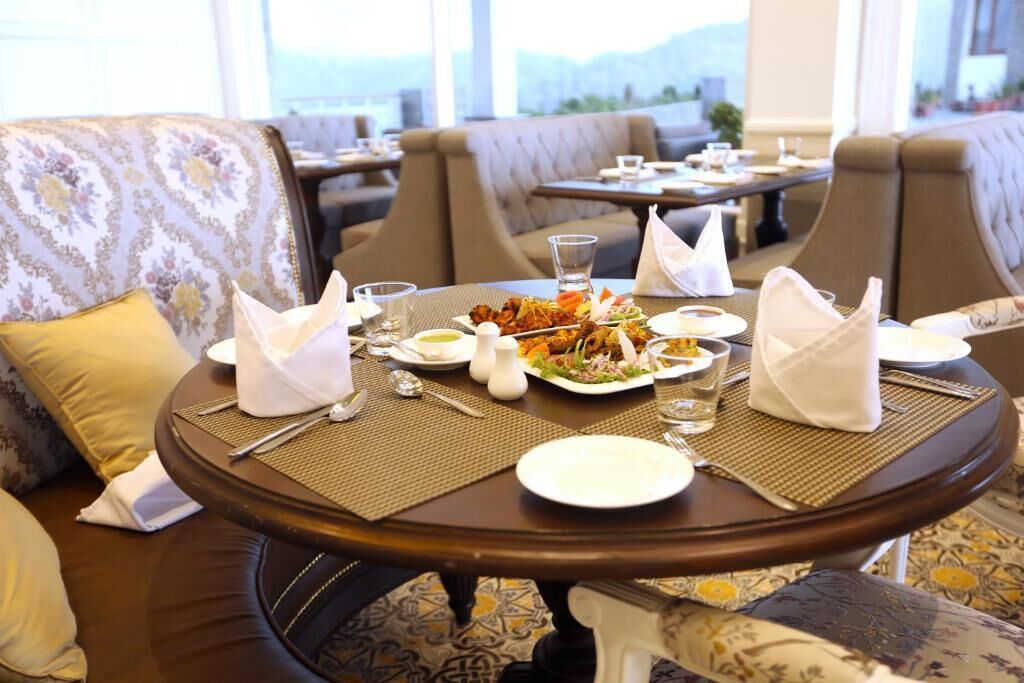 A dining area with a table set for two, including plates, cutlery, and napkins.