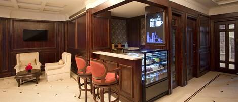 A bar area with wooden paneling, a glass display case with desserts, and a sign reading "FORTUNE DELI".
