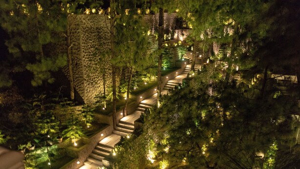 A nighttime view of a terraced garden with stone steps and illuminated pathways, surrounded by dense trees. - Fortune Select Forest Hill, Kasauli - Member ITC Hotels' Group (Solan)