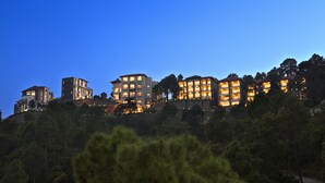 A multi-story hotel with a modern architectural design, featuring multiple balconies and a lush, green landscape in the foreground. - Fortune Select Forest Hill, Kasauli - Member ITC Hotels' Group (Solan)