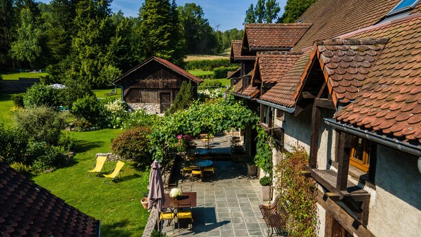 Un caratteristico chalet con patio in pietra, posti a sedere all'aperto e un giardino.
