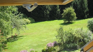 Una vista di un giardino curato con prato, arbusti e piante fiorite.