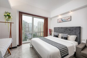 Une chambre d’hôtel moderne avec un grand lit, une vue sur la ville et une table à manger.