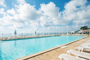 室外游泳池，池畔遮阳伞，日光浴躺椅