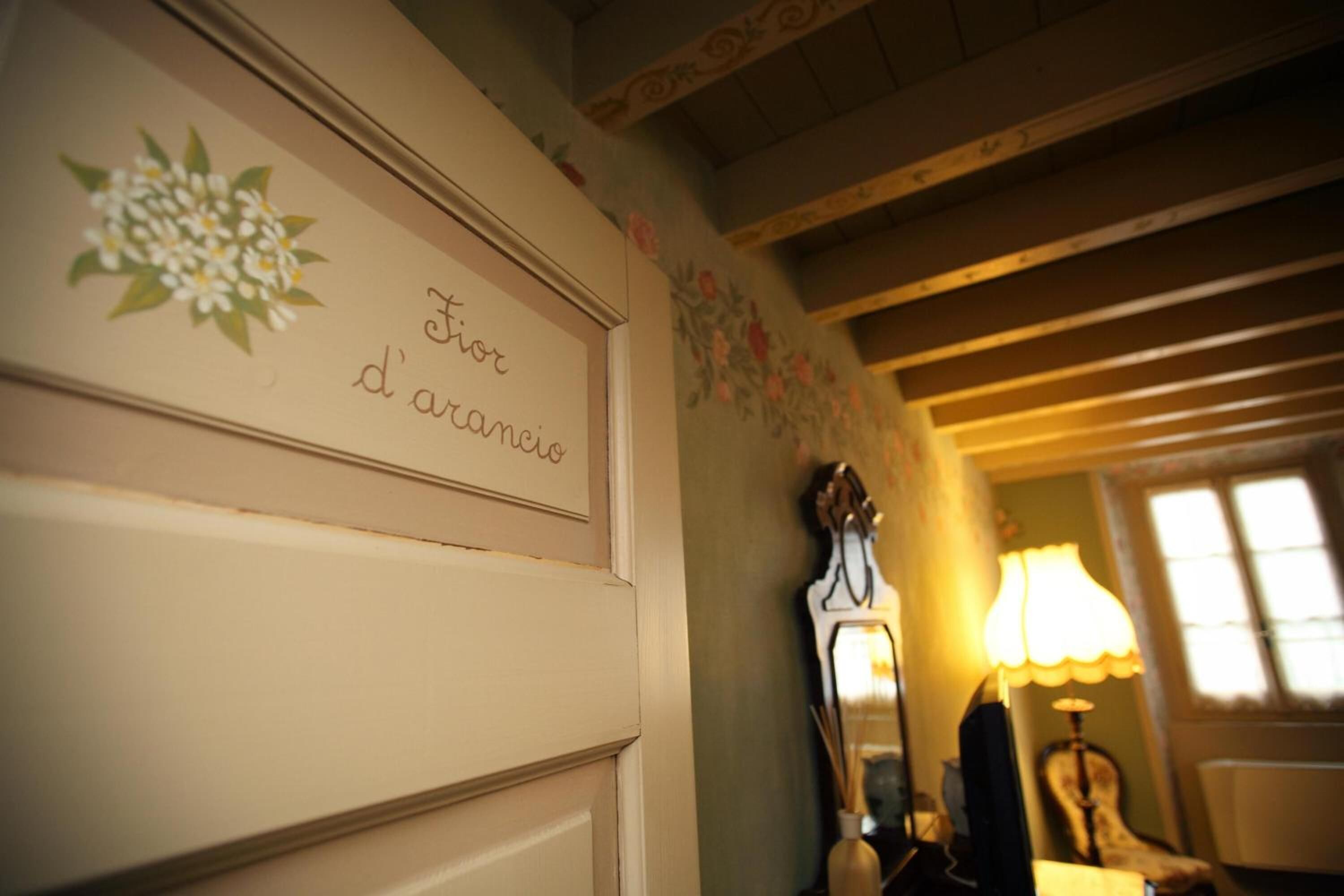 A room with a wooden ceiling, a wall with floral wallpaper, and a sign that reads "Fier d'antanique".