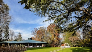 A building with a green roof, surrounded by a well-maintained lawn and trees with autumn foliage. - Villa Valentina (Tradate)