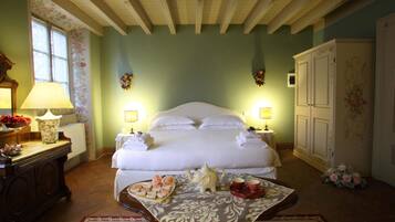 Una camera da letto con un letto grande, abat-jour, una cassettiera e un tappeto a motivi floreali.
