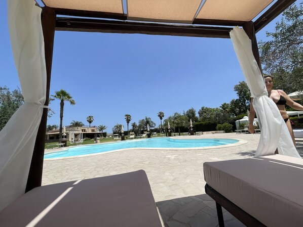 Una piscina al aire libre de temporada, sombrillas