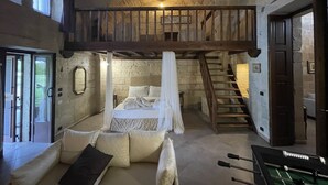A rustic room with a loft bed, a sofa, and a foosball table. - Masseria Giamarra (Carpignano Salentino)