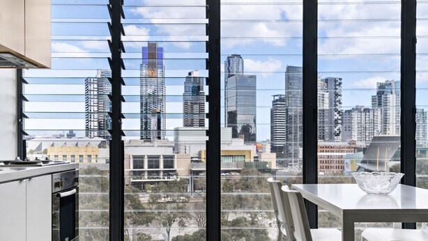 A modern kitchen with a large window overlooking a cityscape. - Leila, 1BDR Melbourne Apartment (Melbourne)