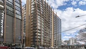 A multi-story building with a modern design, featuring balconies and large windows. - Leila, 1BDR Melbourne Apartment (Melbourne)