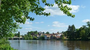 A riverside view with houses and a bridge. - Camping Le Parc les Atypiques (Availles-Limouzine)