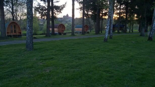 A campsite with several wooden cabins surrounded by trees. - Camping Le Parc les Atypiques (Availles-Limouzine)