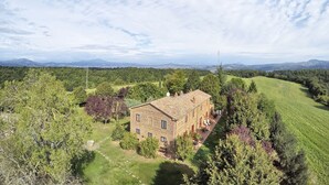 Ein Steinhaus mit Garten und Blick auf ferne Berge.