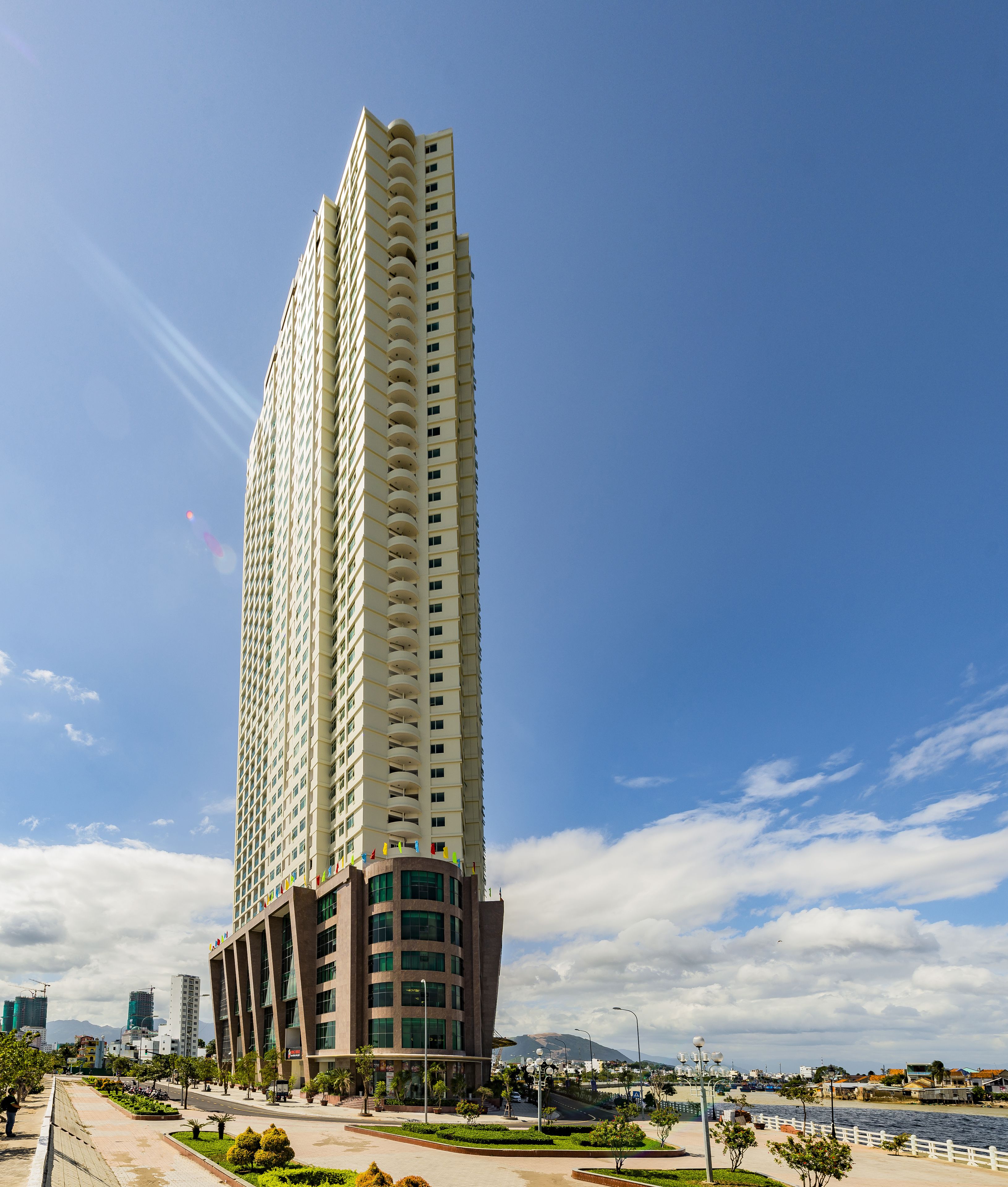 Un edificio moderno y alto con un diseño arquitectónico único, que combina elementos cilíndricos y rectangulares.