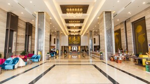A spacious lobby with a central seating area, a reception desk, and a decorative chandelier. - Muong Thanh Luxury Khanh Hoa Hotel (Nha Trang)