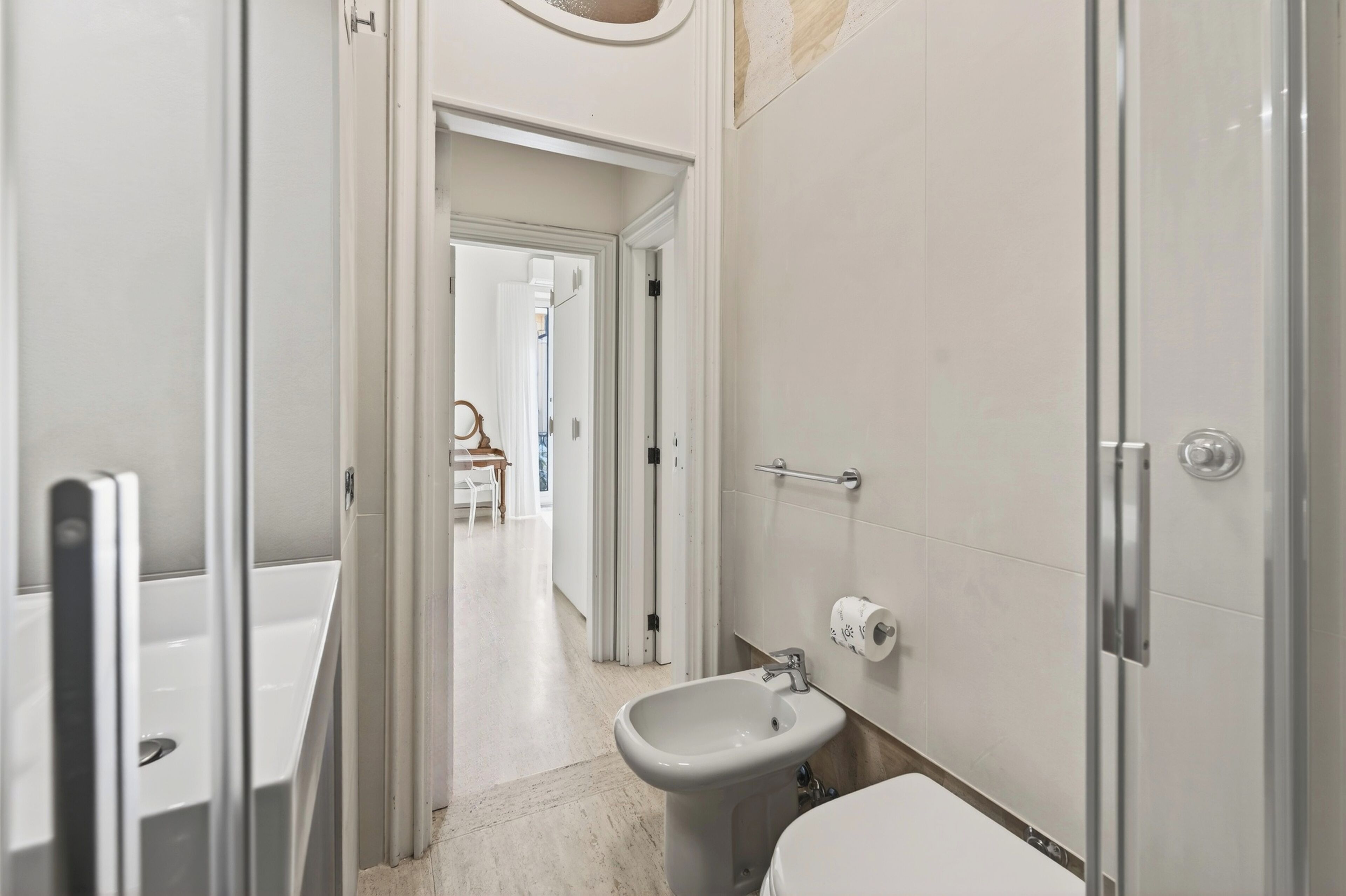 A bathroom with a toilet, bidet, and shower.