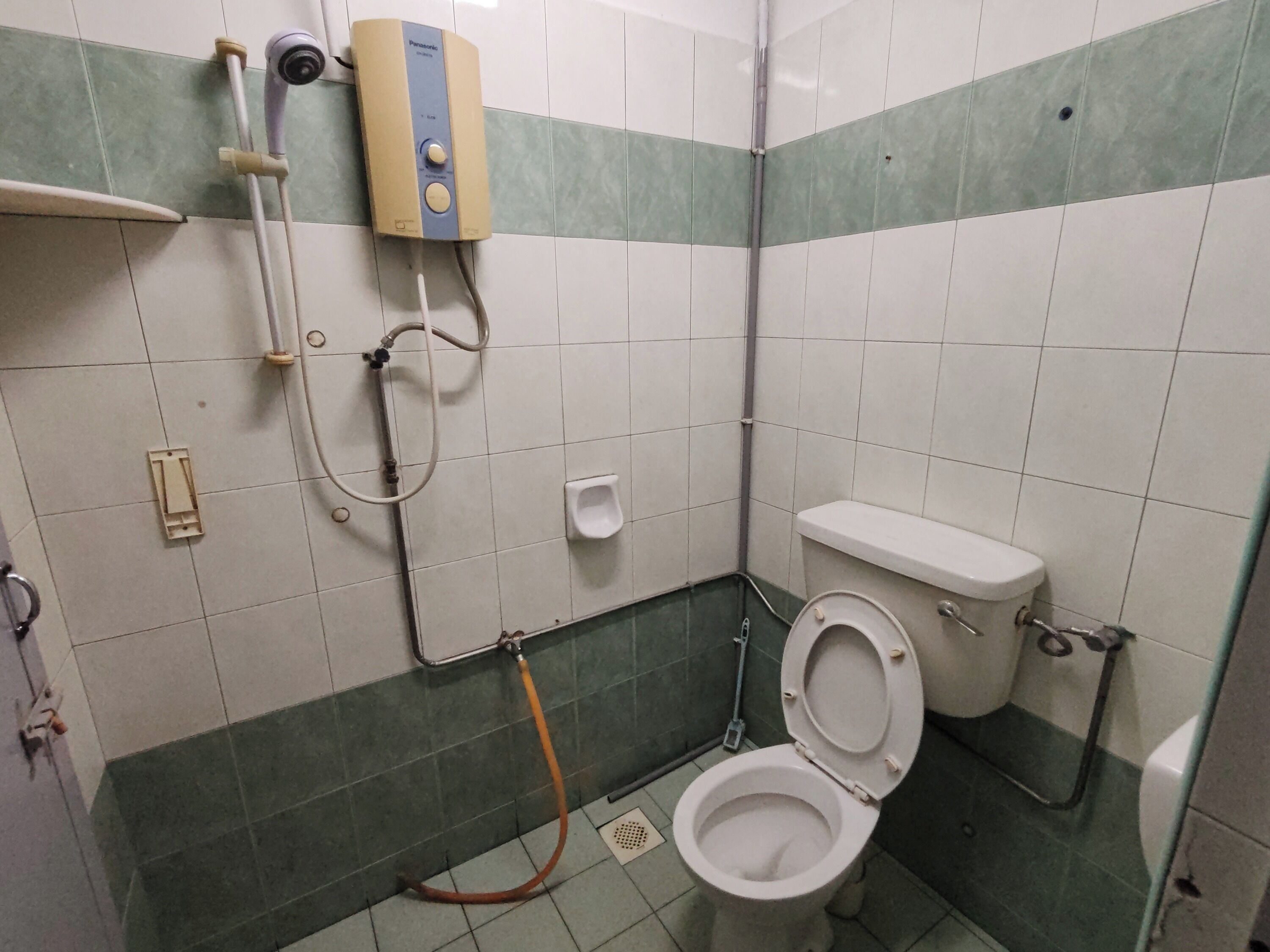 Um banheiro pequeno com vaso sanitário, chuveiro e mictório.
