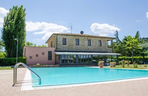 A two-story stone building with a swimming pool in front. - Hotel Villalago (Magione)