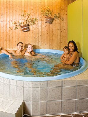 A family in a hot tub with wooden walls and tiled flooring. - Burghotel (Geislingen an der Steige)