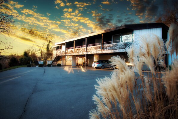 A two-story building with a covered parking area and a car parked inside. - Burghotel (Geislingen an der Steige)