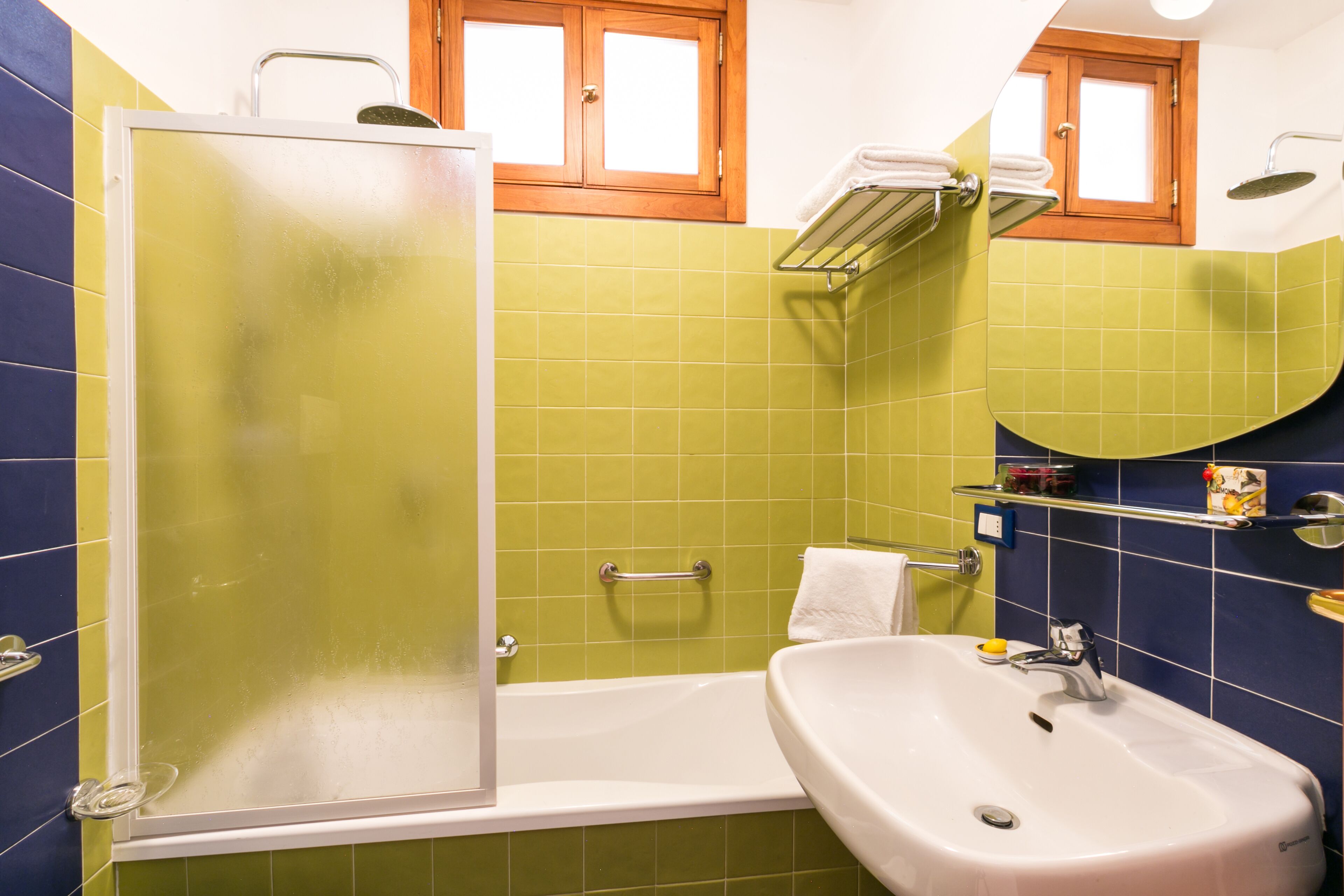A bathroom with a bathtub, a shower enclosure, a sink, and a mirror.