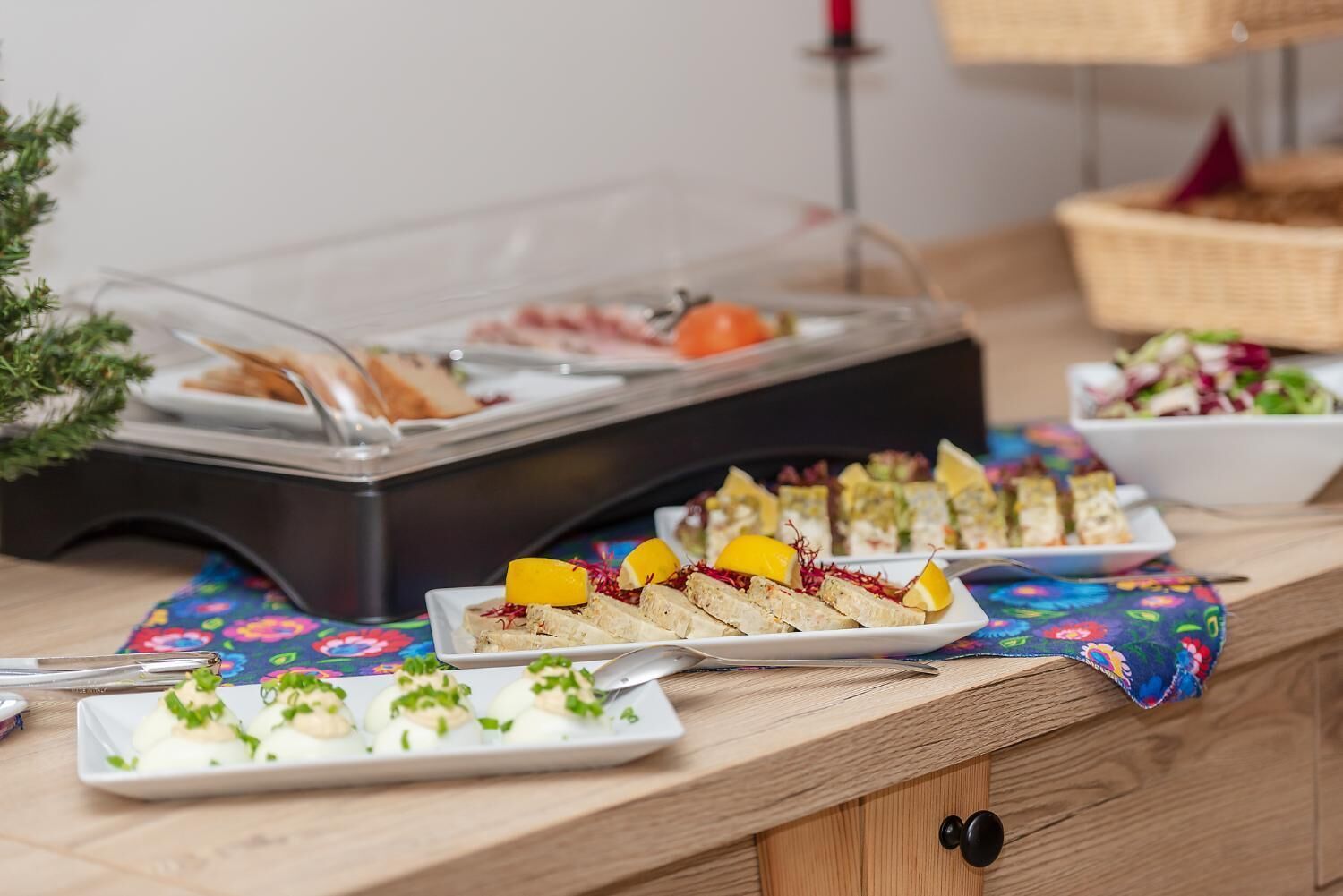 A buffet table with various food items, including sandwiches, salads, and a covered food station.
