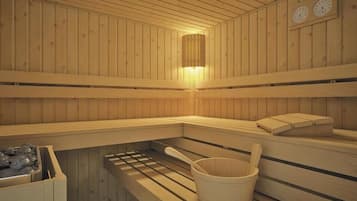 Una sauna con paredes de madera, un banco, un balde y un calentador.
