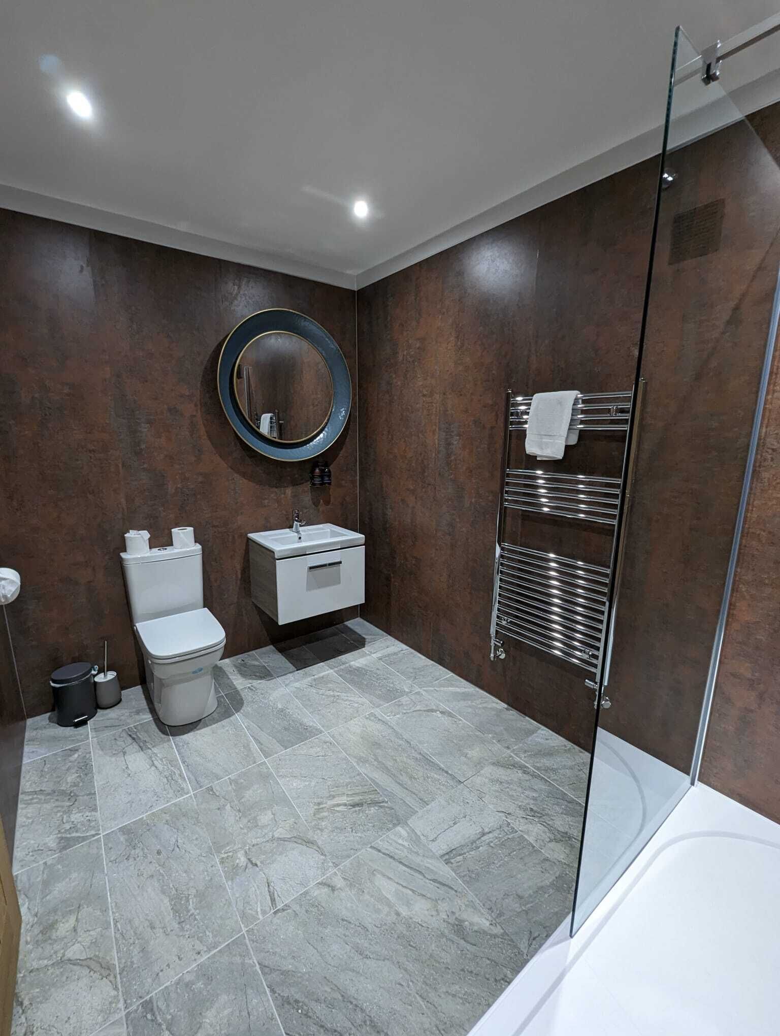 Een moderne badkamer met toilet, wastafel en douchecabine van glas.