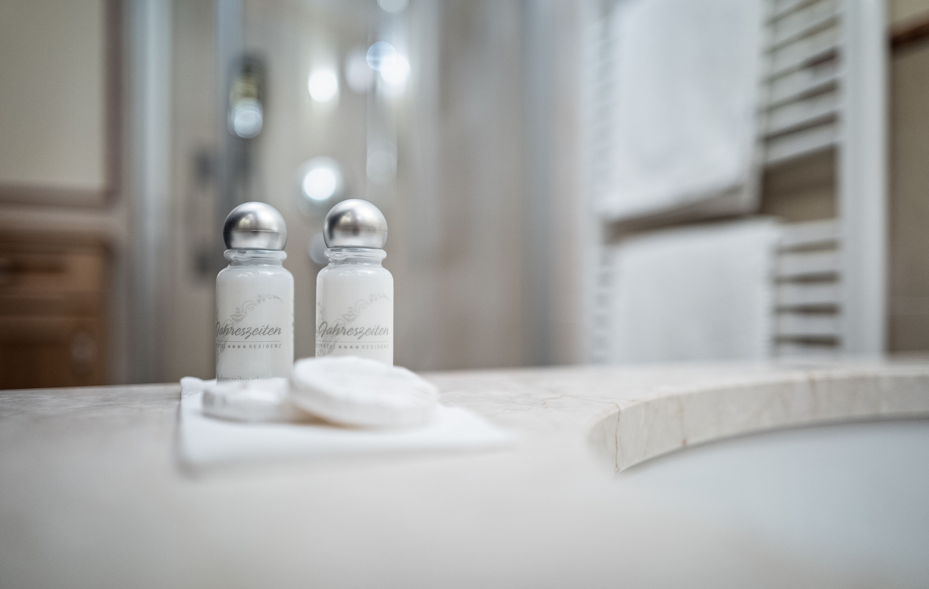 A bathroom with a marble countertop, two salt and pepper shakers, and a white towel.