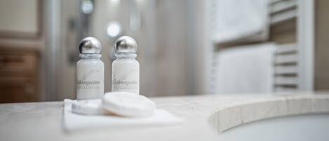 A bathroom with a marble countertop, two salt and pepper shakers, and a white towel.